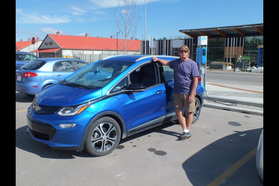 Steve Repic charges his Chevy Bolt at the charging station beside The Station in Cochrane.