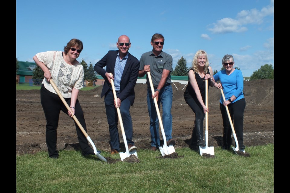 After securing over $2.5M in public and private donations, the new multi-purpose artificial turf field, is finally being built at Cochrane High School.  It will serve as a safe place for students, community members, and visitors to play and gather. The artificial turf field will be permanently marked for football, rugby and soccer and have a certified rugby shock pad. There will also be improvements to lighting, the scoreboard, fencing, and bleachers. 
In photo L to R: Town of Cochrane Coun. Tara McFadden, Cochrane Mayor Jeff Genung, Rocky View County Mayor Don Kochan, President  of the Cochrane Track and Field Association Leslie Ann Kalman, and Treasurer of the Cochrane Track and Field Association Sandie Harrison.