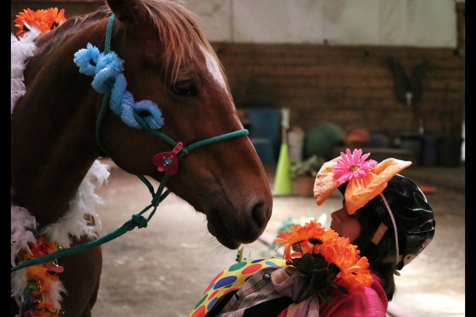 Grade 6 student Mackenzie T. playfully dodges a curious Willow after finishing their walk down the runway. (Jessica Lee/The Cochrane Eagle)