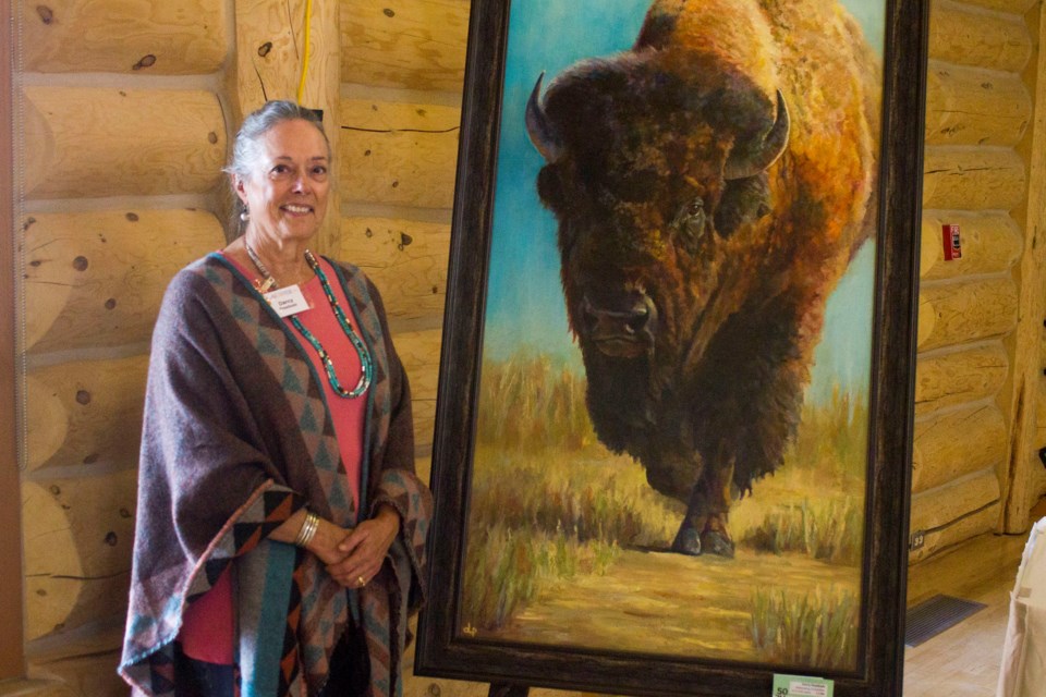 Cochrane Art Club member, Darcy Presiloski, with her piece 'Welcoming Committee,' at the club's annual May Art and Show Sale on May 6.