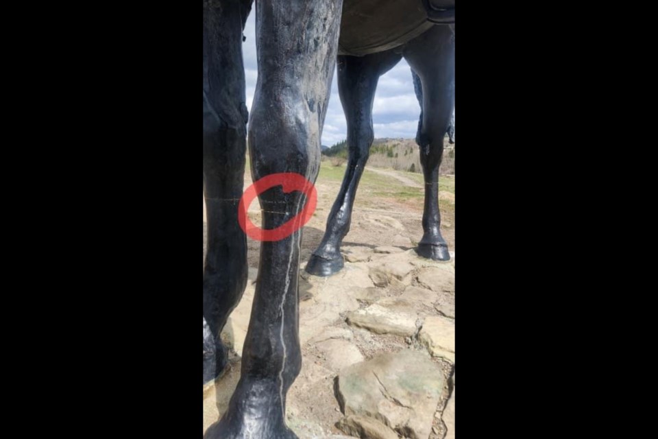 Clear marks around the legs of the Men of Vision statue in the Cochrane Historic Ranche.