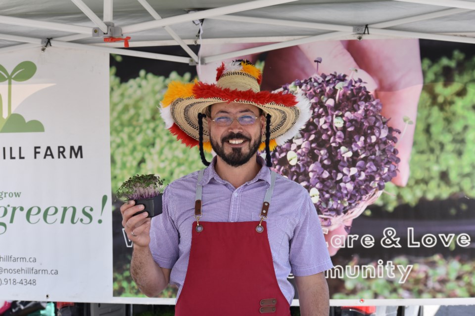 Sam Nahill in front of his collard greens tent at the Cochrane farmers market in the Spray Lake Sawmills Family Sports Centre parking lot