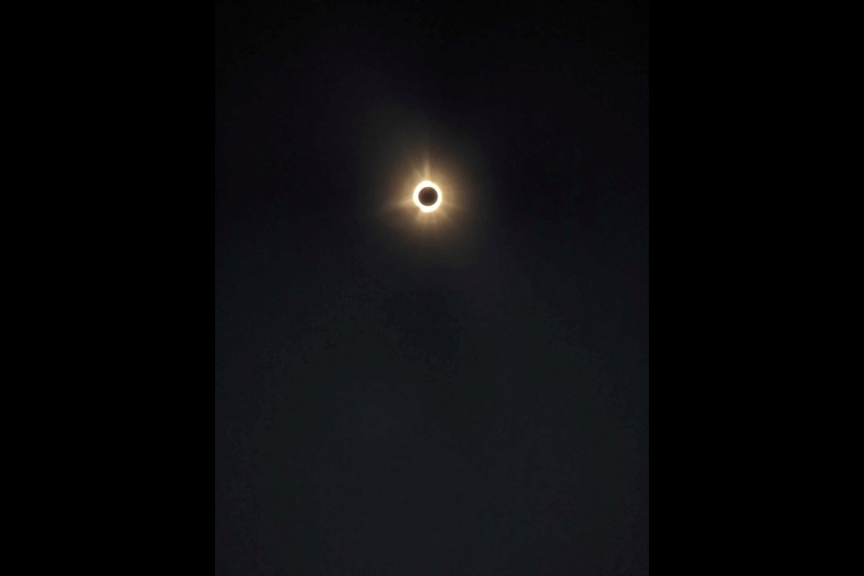 Tim Giese of the Cochrane Environmental Action Committee travelled to little Rogersville, near Miramichi, NB, to experience the total eclipise yesterday. The weather was gorgeous with barely a cloud in the sky.  “It was quite the experience with the light dimming slowly until about 95 per cent coverage and then as the eclipse moved to totality watching a ‘wall’ of darkened sky zoom in from the west.  While the sky above us was dark all around us on the horizon a sky like a sunset or sunrise.  Venus and Jupiter were clearly visible,” Giese said.