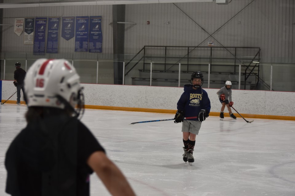 Kids wore t-shirts on this hot sunny day as they practiced during the drop-in hockey at the SLS Centre