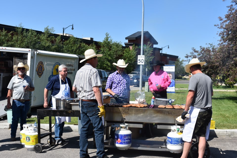 Cochrane Lions Club members working the grills at the Airdrie-Cochrane Constituency Stampede BBQ 
