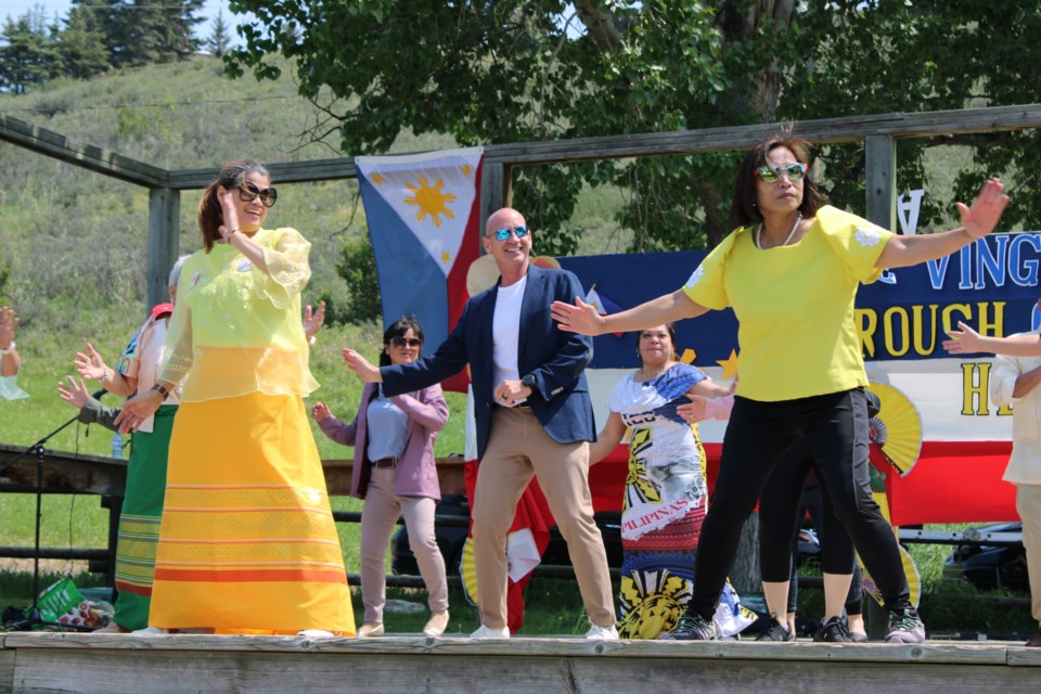 Mayor Jeff Genung joins Cochrane's Filipino community in a communal dance on Saturday, June 7 at the Historic Cochrane Ranche Site.