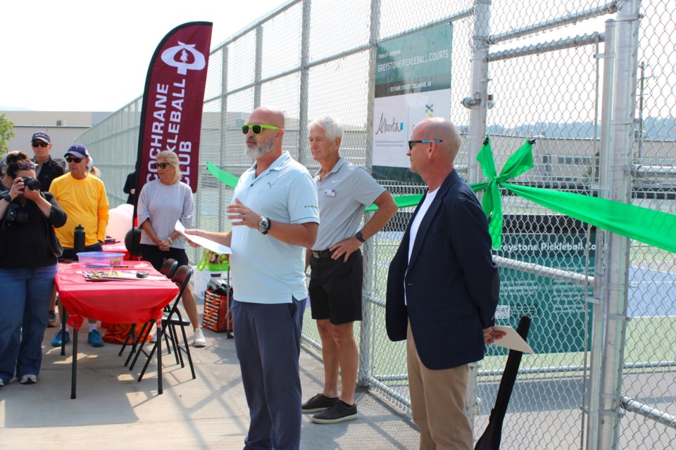 Jeff Hagan of Burnswest speaks at the ribbon-cutting event on June 7 while standing alongside Cochrane Pickleball Club President Greg Young and Cochrane Mayor Jeff Genung.
