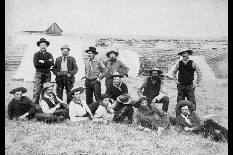 Stanley James, front and centre, poses for a photo in May of 1893 alongside 12 cowboys near Jumping Pound Creek.