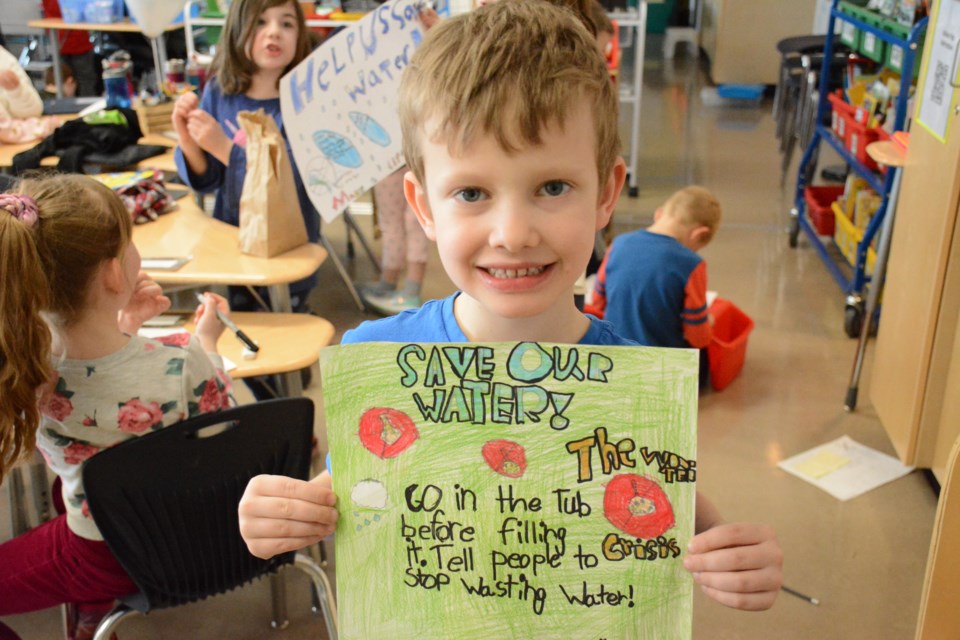 Grade 2 student, Grayson Moring proudly shows off his water poster.