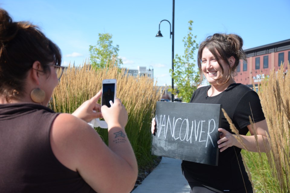 Menann Klassen (left) takes one of the first photos for the Faces of Cochrane Mosaic (Right) Stephanie