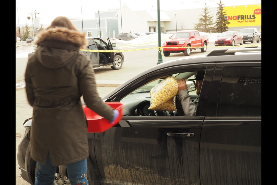 Cochranites came out in full force Saturday afternoon to donate cash and food and receive Cochrane Movie House popcorn in return. Photo by Cathi Arola