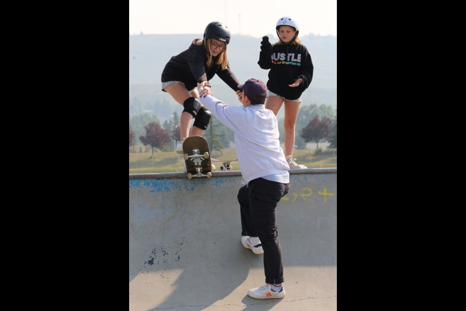 Shredz Skate Shop Sam Stuart helps 12-year-old Jayden drop in on a quarter pipe. (Tyler Klinkhammer/The Cochrane Eagle)