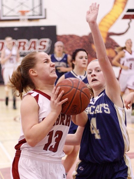 Cochrane High School Cobras&#8217; Kseniya Parsons takes it to the rack against Bow Valley High School Bobcats&#8217; Lauren Murphy in Cochrane Classic basketball