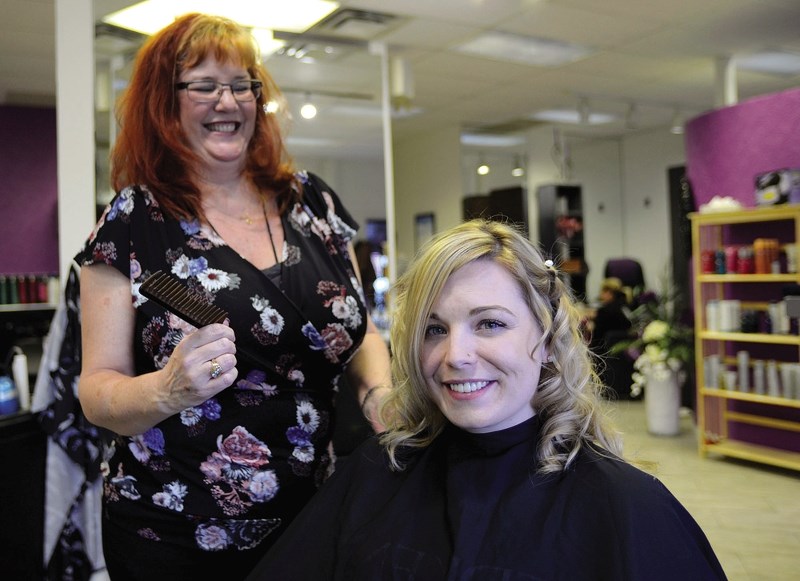 Fringes senior hair stylist Donna Kennedy shows one of many ways to wear your hair down with Fringes owner Sarah Quinlan.