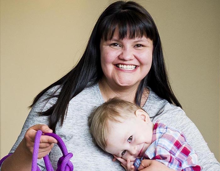 Valentina Fenton with her 18-month-old son Darroch show dog leashes made from climbing rope donated by the Stronghold Calgary Climbing Centre, which she will be selling for