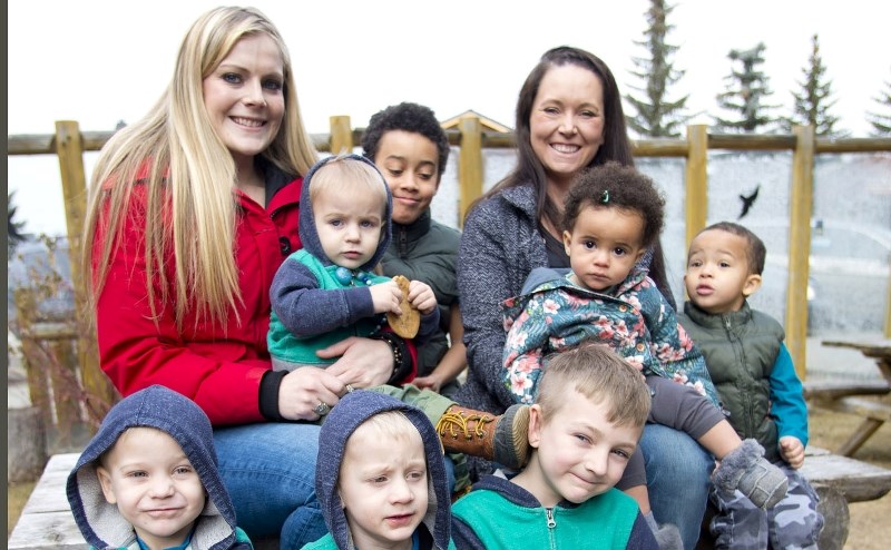 Kara Balcarras (red jacket) and Christina Vitalis are looking for support to pursue their vision of opening a Cochrane play centre. From left, front row: twins Samson and
