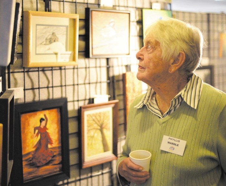 Phyllis Wardle checks out some pieces of art at the Foothills Art Club annual art show last fall.