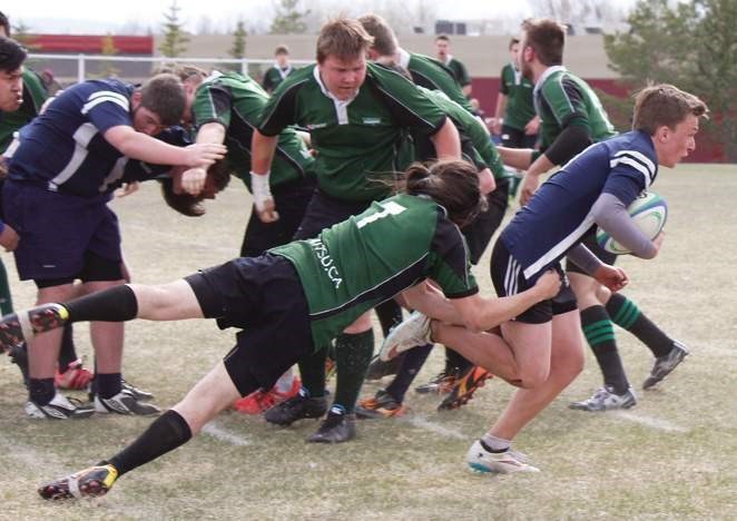 Springbank Community High School Phoenix Makani Clapson tries to wrap up Cochrane Rugby ball-carrier Rylen Waugh in Big Sky Rugby Union high school boy&#8217;s play May 13 at 