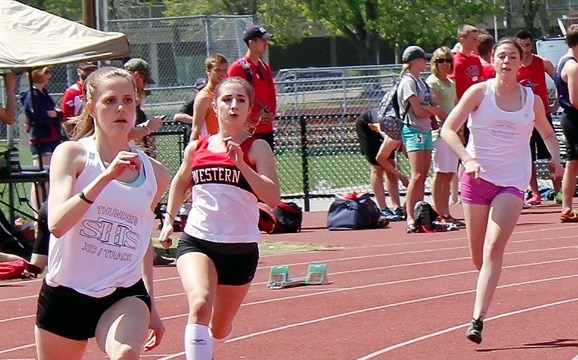 St. Timothy Thunder sprinter Laura Huck (right), Western&#8217;s Natalie McDougall and Thunder&#8217;s Seela Wulff charge into the first turn in Calgary Senior High School
