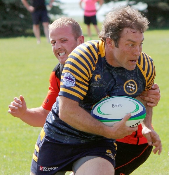 Bow Valley Grizzlies player/coach Ty Hawes chews up yards in Calgary Rugby Union play vs. Foothills Lions of Okotoks on June 6 in Cochrane. Hawes scored three tries in