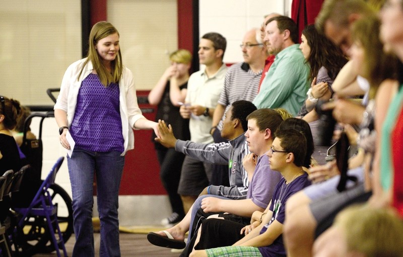 Autumn Bernard receives a high-five from students and guests in attendance at the Cochrane High School academic and athletic awards ceremony June 11.