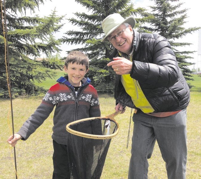 Eight-year-old Derrick Martin with his first fish after getting fly-fishing instructions from Ken Stevenson during the Glenbow Ranch Park Foundation&#8217;s class last week.