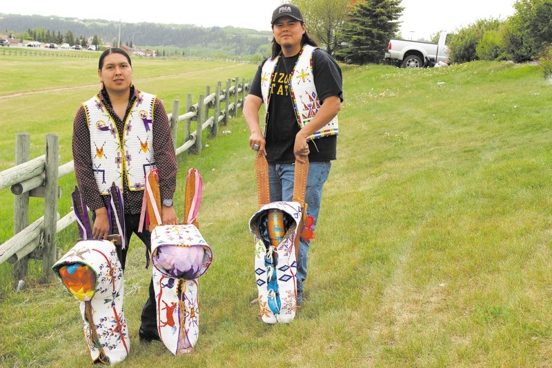 Artists Eli Snow, left, and Cameron Kootenay with their cradleboards and vests.
