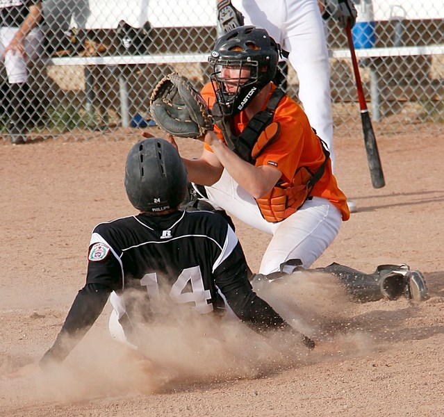 Cochrane Crush catcher Cole Avery waits for the throw to the plate as Airdrie base runner slides safely for a run in June 25 Senior Big League championship final at Airdrie.