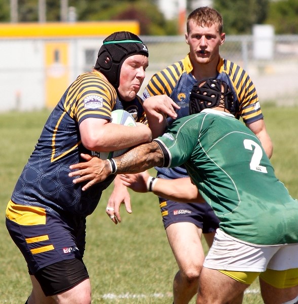 Bow Valley Grizzlies prop Karl Bauer pounds the ball inside as teammate Connor Gilbert supports the play in Calgary Rugby Union Second Division men&#8217;s rugby action vs.