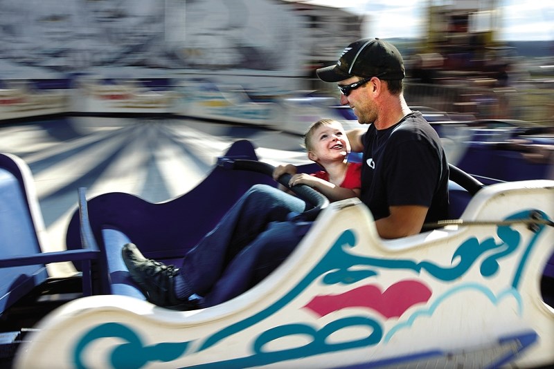 Brian Levesque and his son, Caleb, enjoy one of the ride at last year&#8217;s Cochrane Fall Fair. This year&#8217;s event runs from Aug. 21-23 at the Cochrane Ag Society