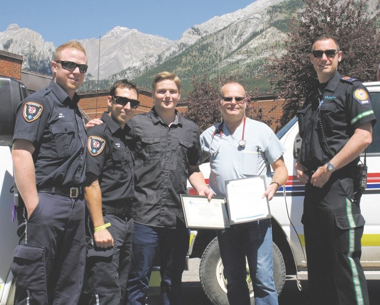 Canmore resident Liam Hawkins receives the EMS Citizen Recognition Award July 18 at the Canmore Hospital. (Left to right): Joe Casurella, Nakoda EMT; Sylvain Frechette,