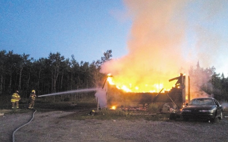 Exshaw firefighters battle a blaze at a Morley residence Aug. 7. Cochrane RCMP have confirmed the fire to be arson.