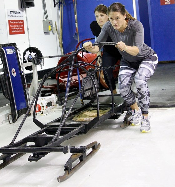 Brakeman Janine McCue of Cochrane (from left) and driver Christine de Bruin of Calgary show their form during female two-man bobsleigh training at WinSport Winter Sport