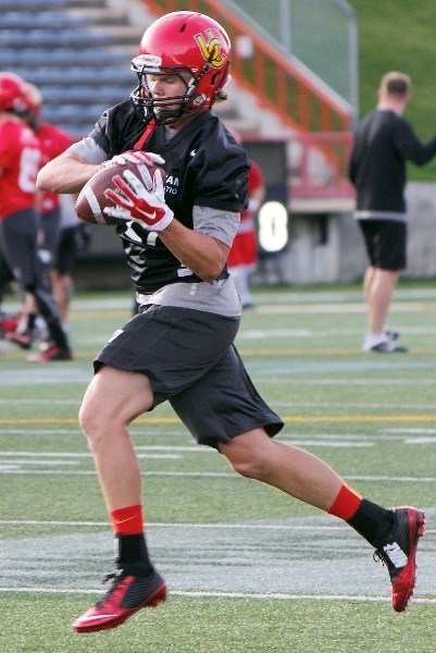 Bow Valley High School Bobcats 2015 grad Scott Haigh stabs a ball during defensive-backs drills at University of Calgary Dinos football practice on Aug. 31. In his rookie