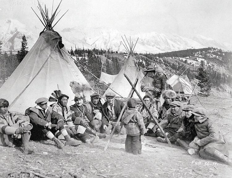 On location for the 1922 film Valley of Silent Men at the famed Tunnel Mountain near Banff. An unidentified child stands in front of (left to right) three unidentified men,