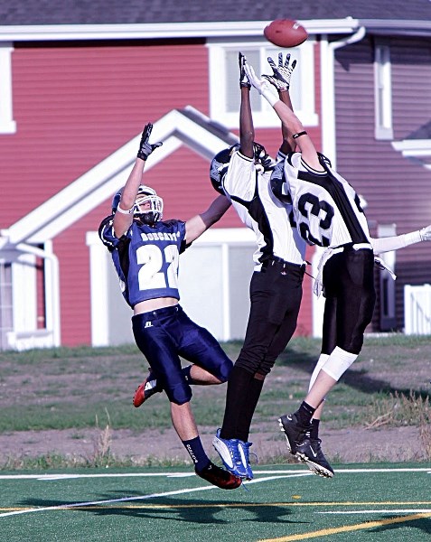 Bow Valley Bobcats receiver Nathan Hillier (left) goes up for a pass in Rocky View Sports Association high-school football play vs. visiting George McDougall Mustings on