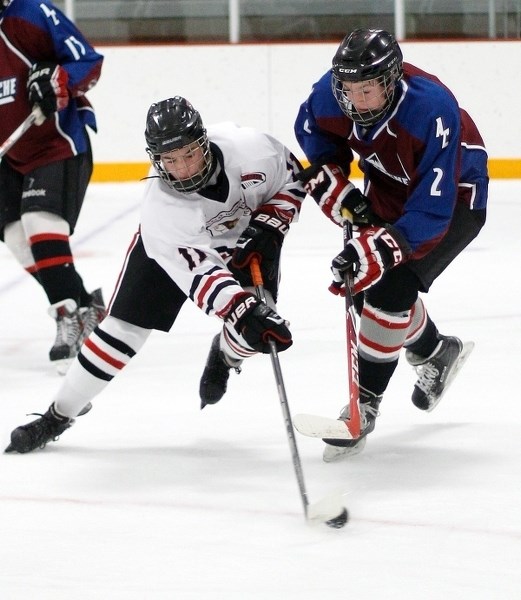 AC Avs&#8217; Luke Jensen, right, challenges for the puck in Alberta Minor Midget AAA Hockey League play.