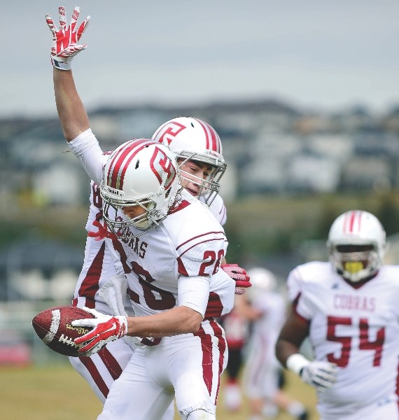 Cochrane High School Cobras Evan Perrault and Erik Nusl celebrate Nusl&#8217;s touchdown in Rocky View Sports Association varsity football play vs. Chestermere High School