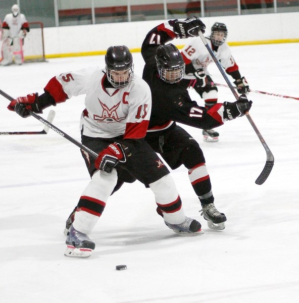Airdrie Lightning&#8217;s Mitchell Konschuk (left) and Bow Valley Timberwolves&#8217; Tristin Dixon go for the puck in South Central Alberta Midget AA Hockey League play Oct. 