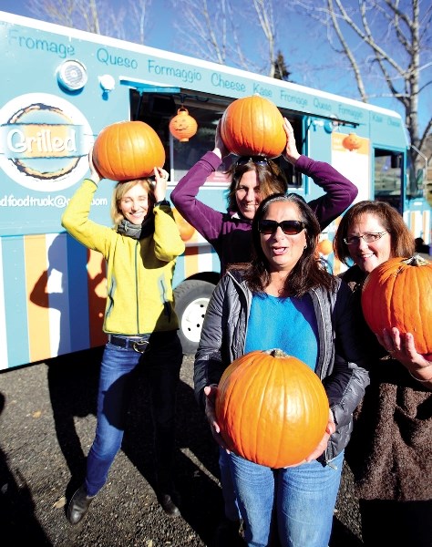 Darlene Clarkson (from left), Vanessa Fischbuch, Christina Singeris, and Janice Dela Mare show off their pumpkins Oct. 20 at the Cochrane Ranche Historic Site backed by