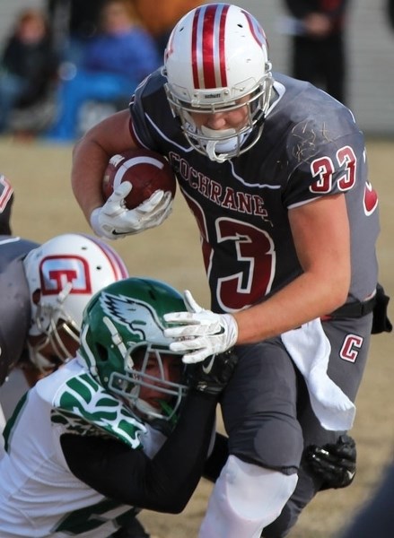 Cobras running-back Kane Boklaschuk (#33) evades a Springbank Phoenix player&#8217;s tackle during Cobras 46-7 victory on Oct. 24. The win cemented Cochrane High&#8217;s