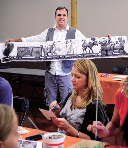 Lewis Lavoie of Mural Mosaic displays the group&#8217;s latest project, a train car to be unveiled at the Tim Bannister Memorial Outdoor Rink. Large groups of artists came to 