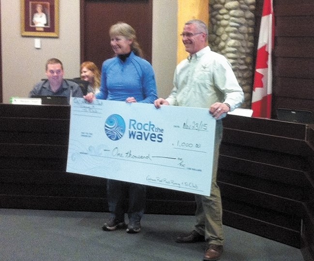 Sheila French, treasurer for Cochrane Red Rock Running and Tri Club, presents Cochrane Mayor Ivan Brooker with a cheque Nov. 23 for $1,000 to go towards the town&#8217;s Rock 