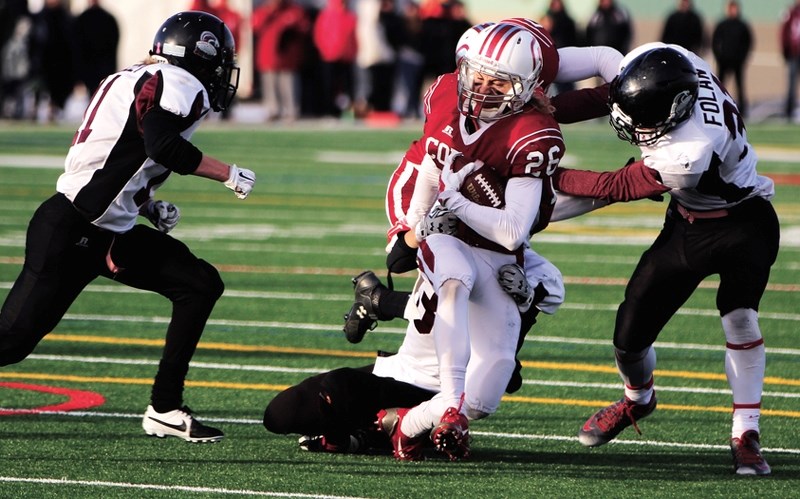 Cobras slotback Erik Nusl (26) avoids the tackles of a couple Rundle College Cobras players during his team&#8217;s 41-17 victory. The win booked Cochrane High&#8217;s place