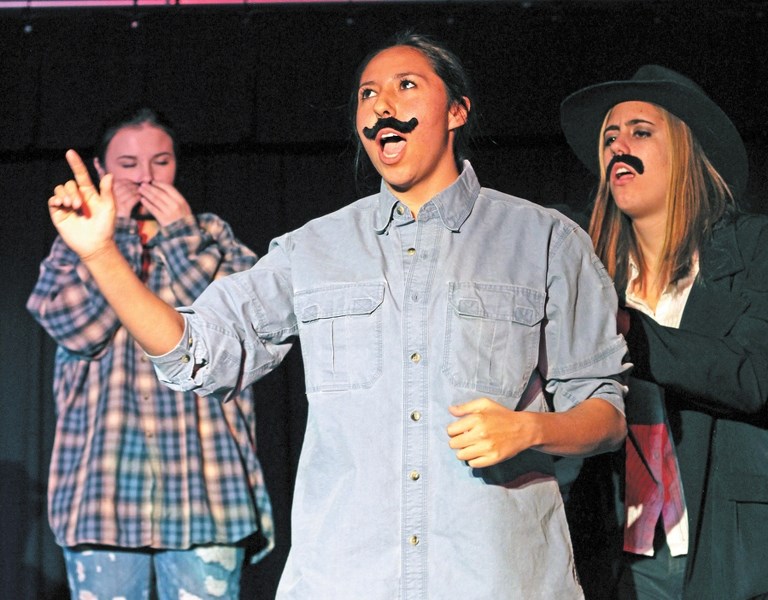 Elainna Noble (centre) makes a bold proclamation on stage with Gav Archibald (left) and Brynn Anderson (right) during a rehearsal for Bow Valley High School&#8217;s
