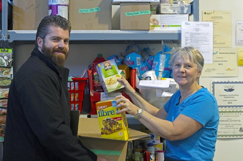Mike Fenton, of Fenton Auto Body, and Ann Beatty, chair of Cochrane&#8217;s Food Bank, pose at the Cochrane Activettes headquarters on Nov. 25. Fenton announced he is raising 