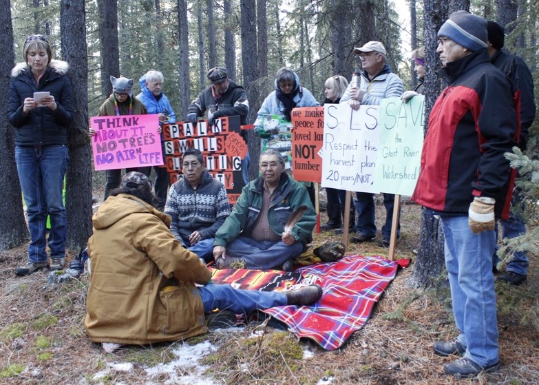 Ghost Valley community&#8217;s Sharon MacDonald (above left) speaks to a gathering of clear cut logging protesters, including Stoney Nakoda elder Sykes Powderface (far