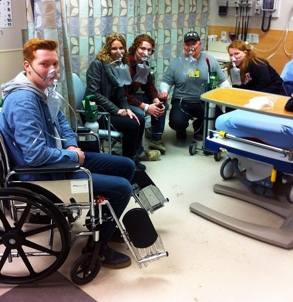 Tucker Irwin (from left), Diane Irwin, Ethan Irwin, Jesse (Richard) Irwin and Ruby Irwin inhale oxygen at Cochrane Urgent Care Centre on Dec. 2 after evacuating their Grand