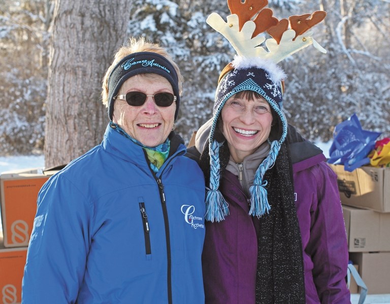 Linda Horwood (left) and Brenda Mottle of the Cochrane Activettes were a part of the volunteer group handing out Share Your Christmas hampers at the Girl Guides Camp Jubilee