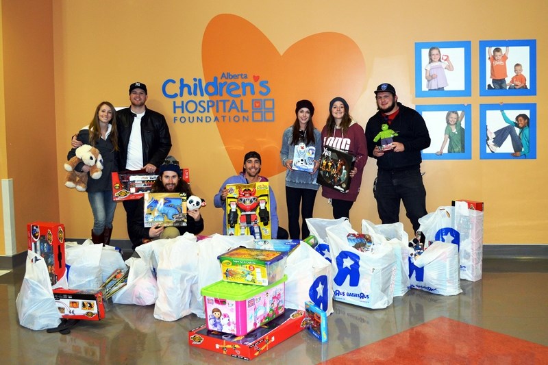 Fundraisers (from left) Chantal Hall, Levi Jessiman, Will McGrath, Tyler Marquis, Ray-Lynn Busslinger, Cait Robson and Alex Burk deliver $2,710 worth of brand-new toys to